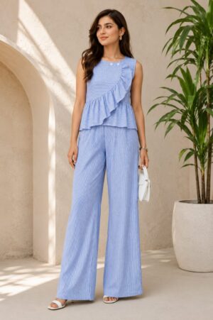Blue pin stripe sleeveless co-ord set with asymmetrical ruffle top and wide leg pants worn by female model in elegant neutral background